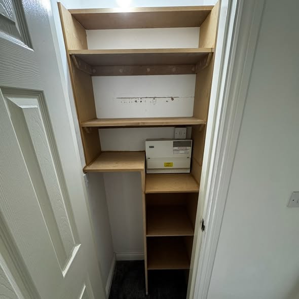 Fitted shelving built into the under-stairs cupboard